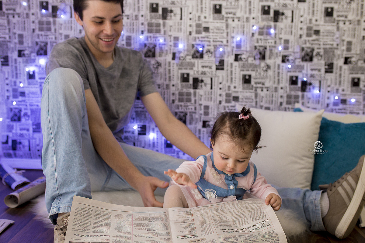 no ensaio de dia dos pais a bebe le o jornal