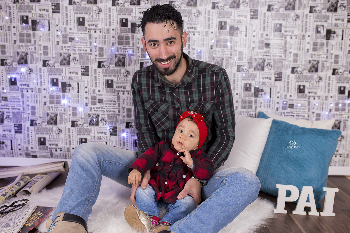 a menina esta no colo do pai para as fotos do acompanhamento mensal