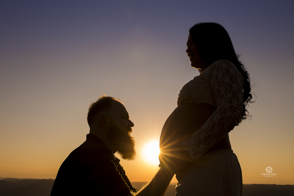 o pai se abaixa na frente da barriga nas fotos do book de gestante externo