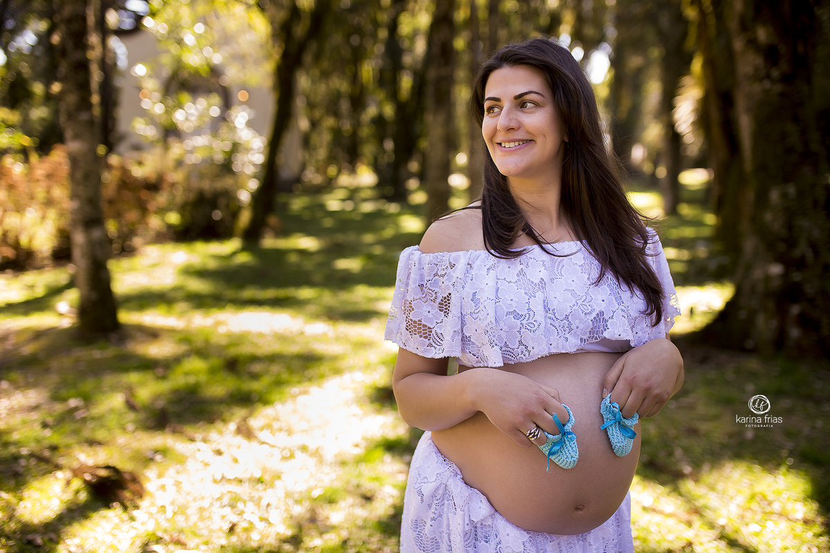 a gestante segura os sapatinhos do bebe