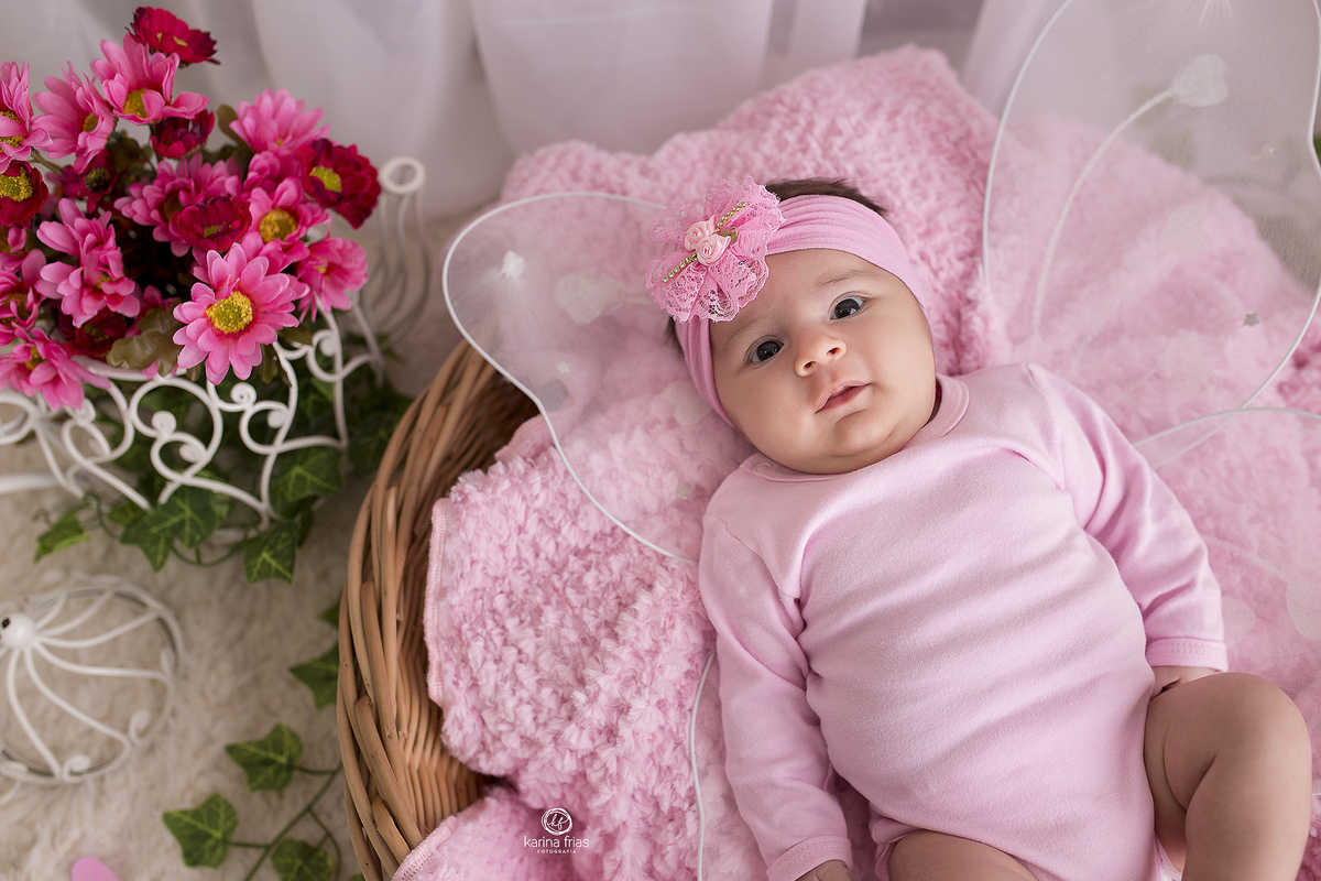 a bebe esta deitada para as fotos de acompanhamento mensal