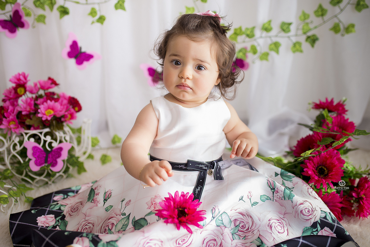 a bebe esta sentada no cenario de borboleta