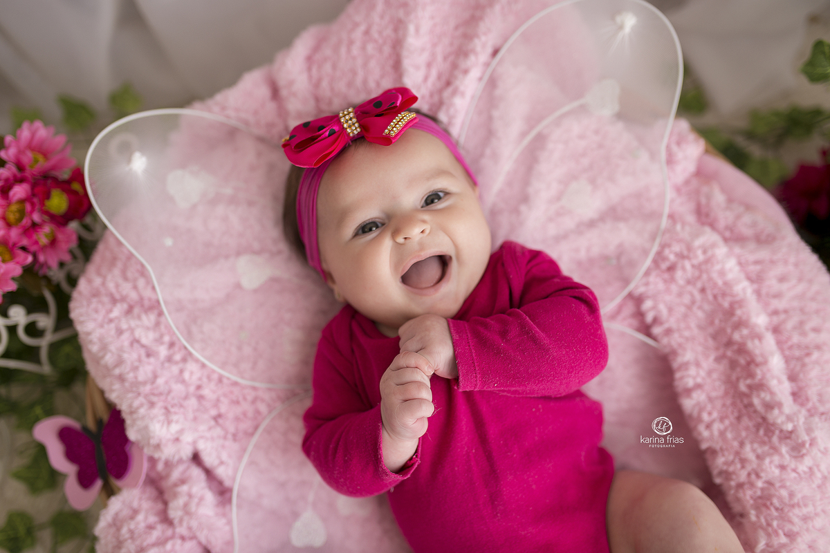 a criança sorri para a fotografa de bebes de caxias do sul, karina frias