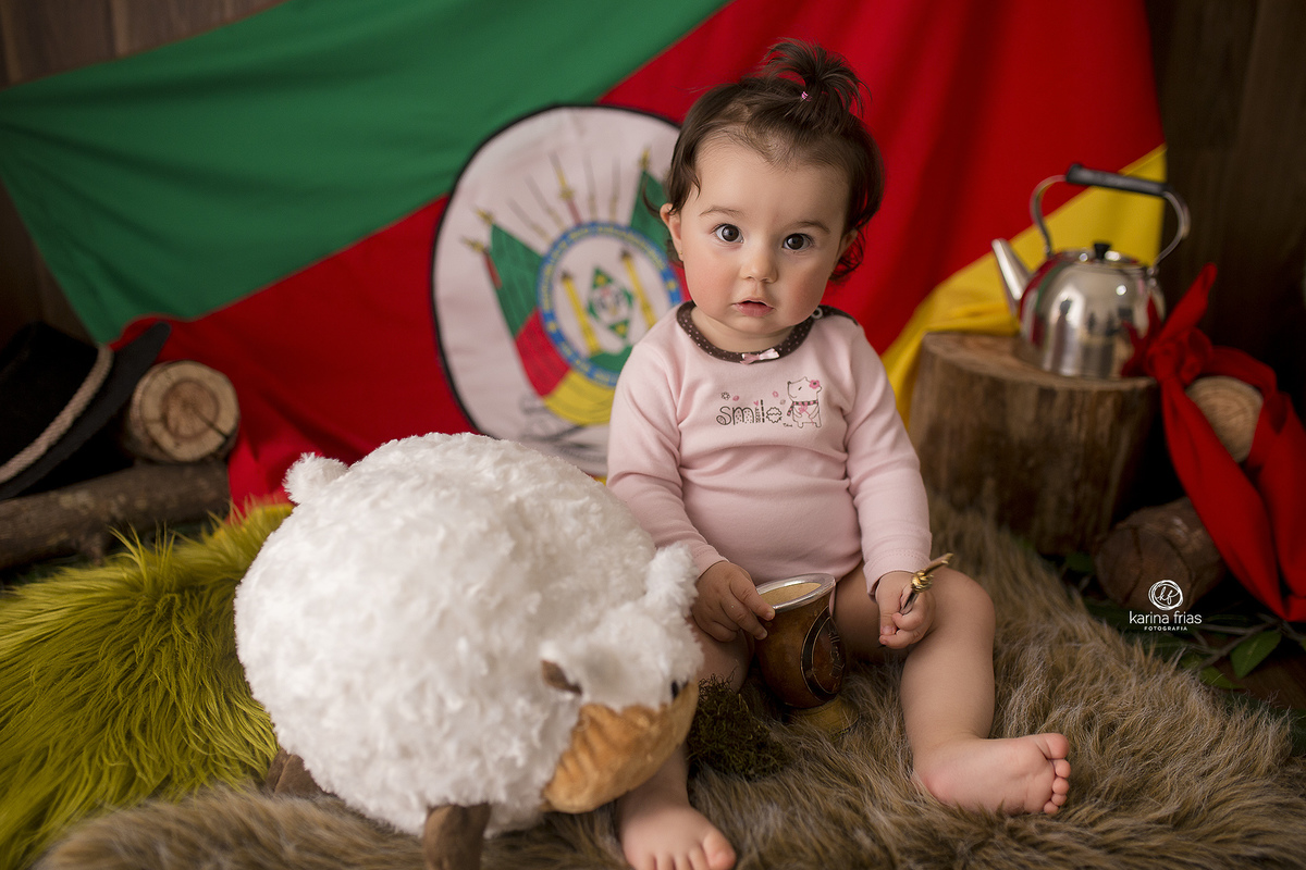 na sessão mensal a bebe brinca com a cuia de chimarrão