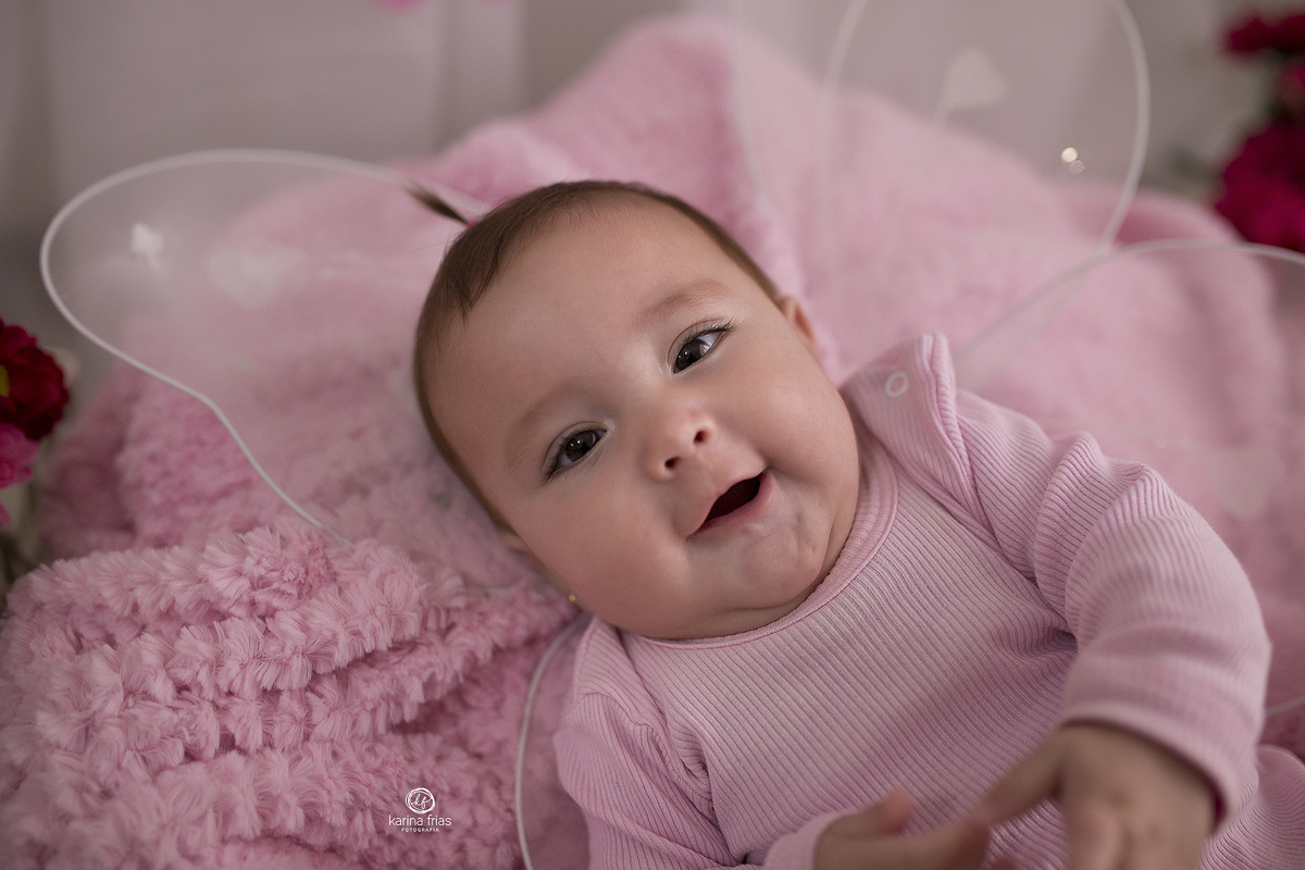 a bebe esta deitada para as fotos dos seus 5 meses