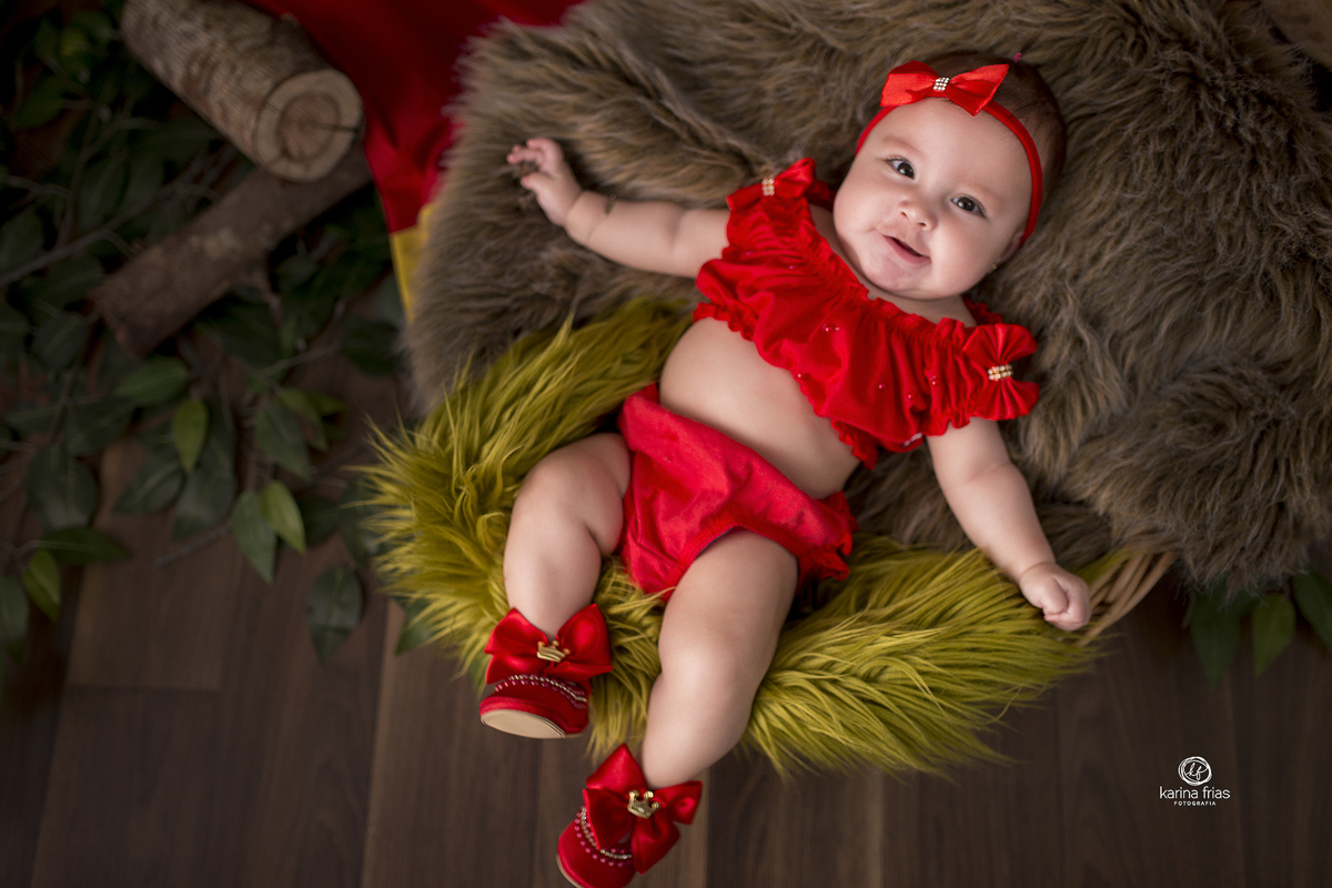 a bebe esta vestida de vermelho em cenario de acompanhamento mensal