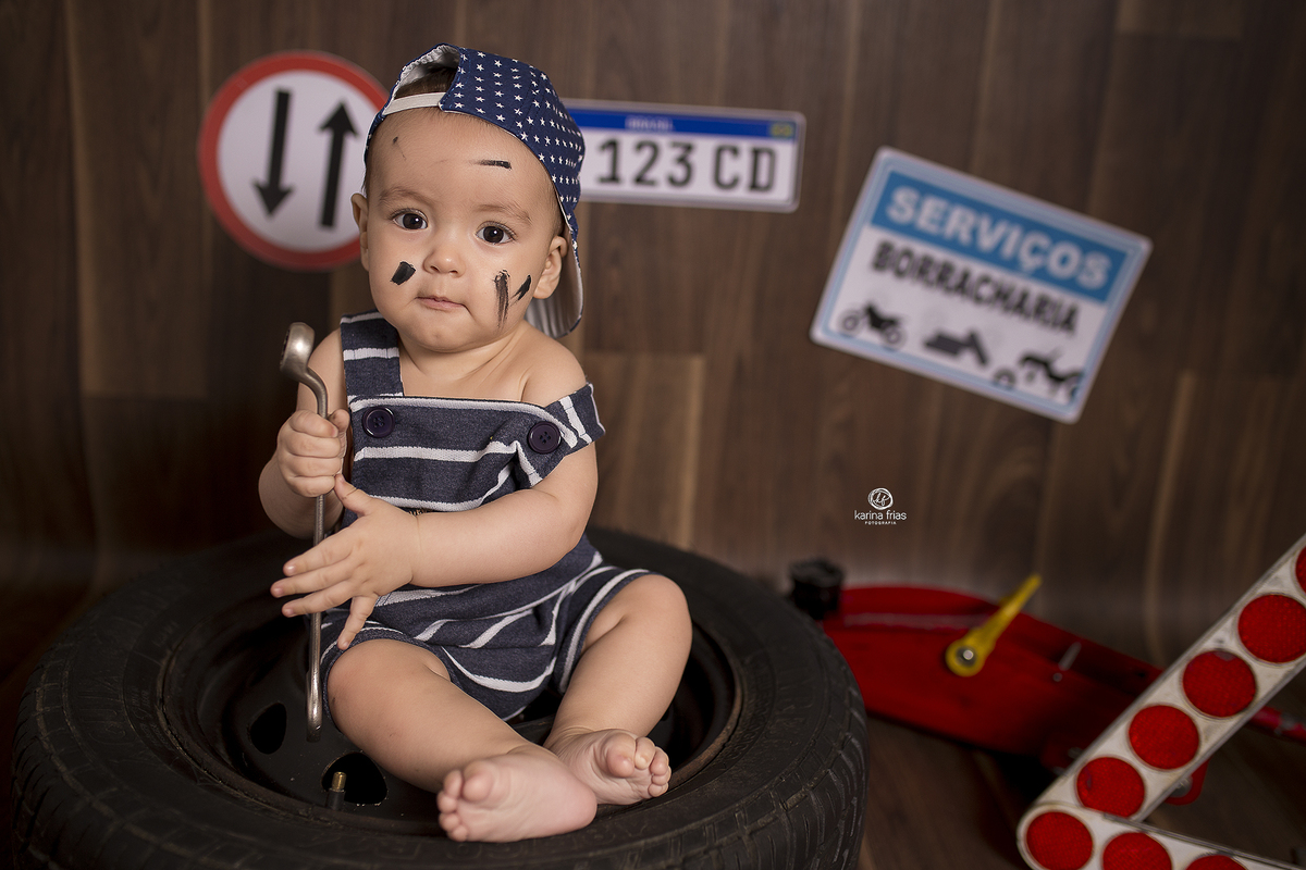 o menino segura a chave de roda no cenario de mecanico