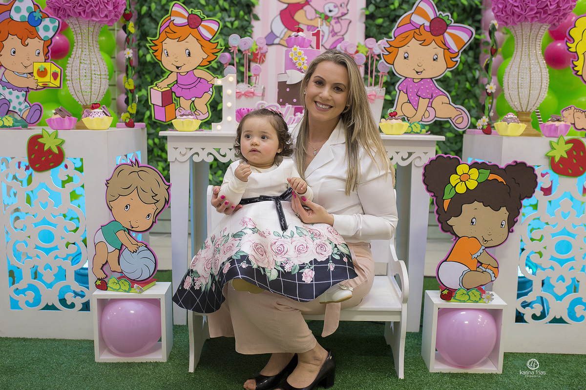 a mae esta segurando a filha no colo no aniversario