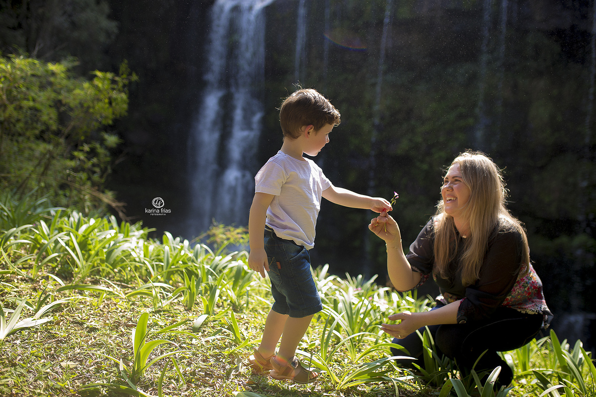 o filho entrega uma flor para a mae no ensaio