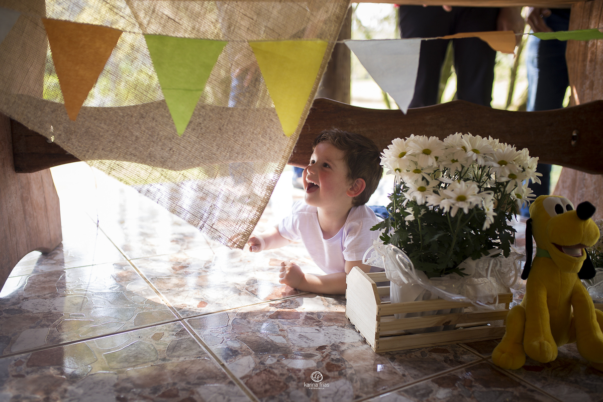 o menino se esconde embaixo da mesa durante as fotos