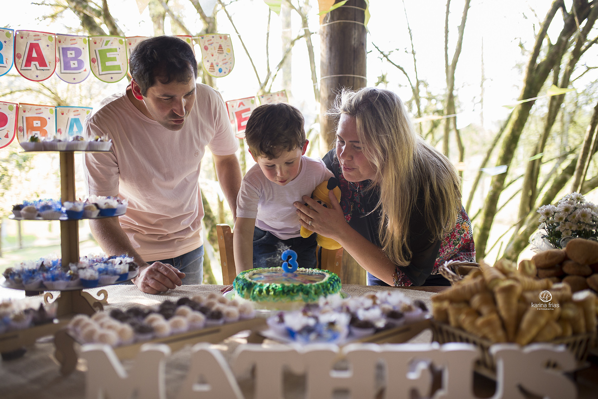 o menino assopra a vela do seu aniversario