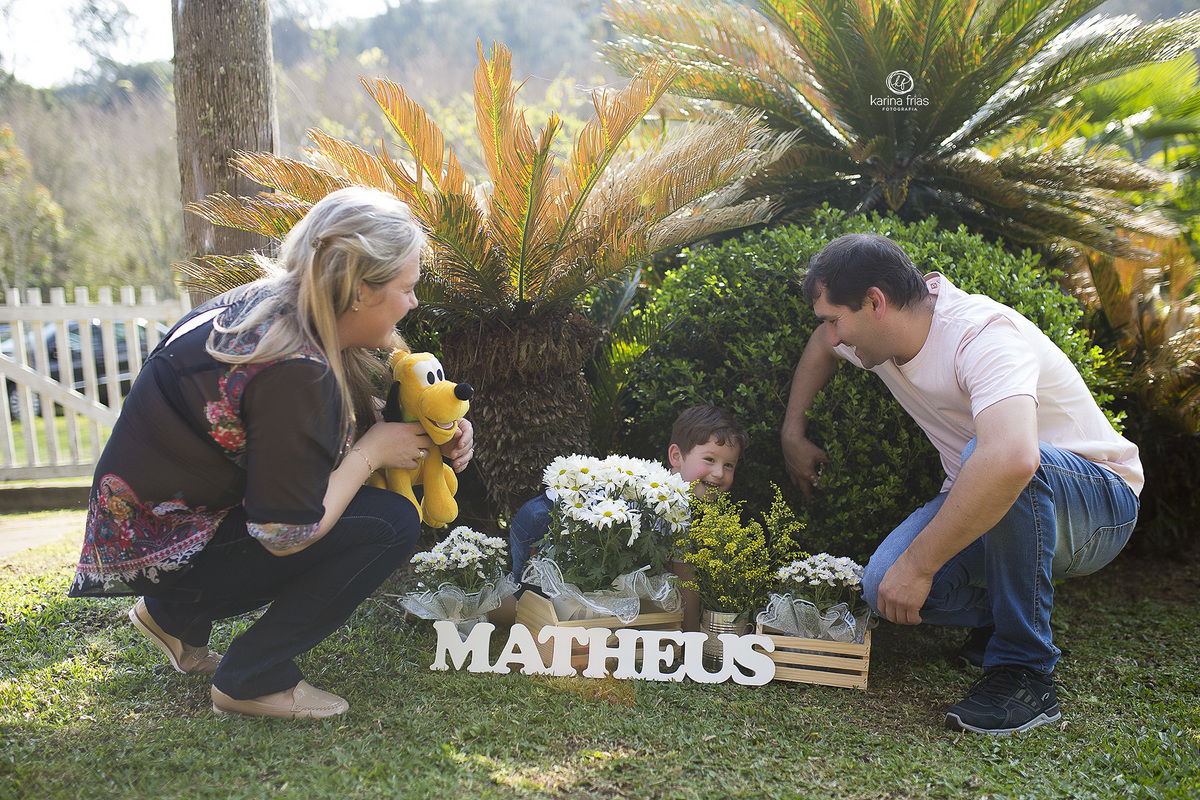 o menino se esconde atras do letreiro enquanto fotografamos a familia