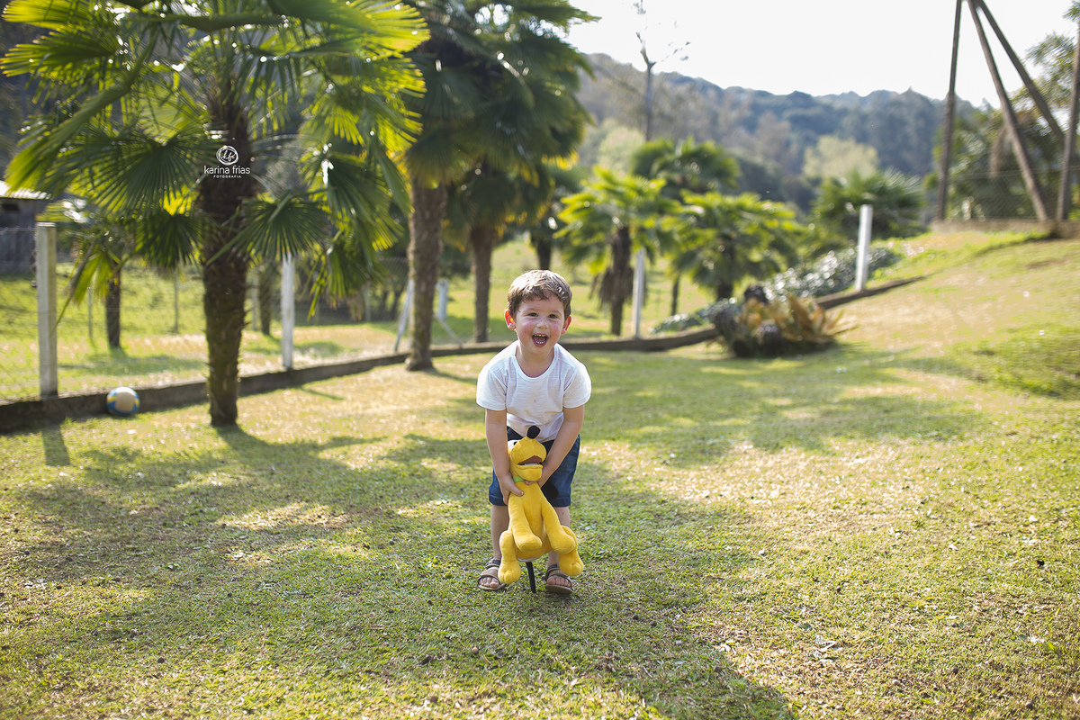 o menino joga seu ursinho para cima no ensaio externo