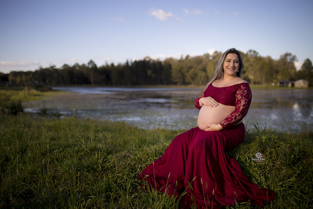 no ensaio externo, a gestante esta sentada beira do lago