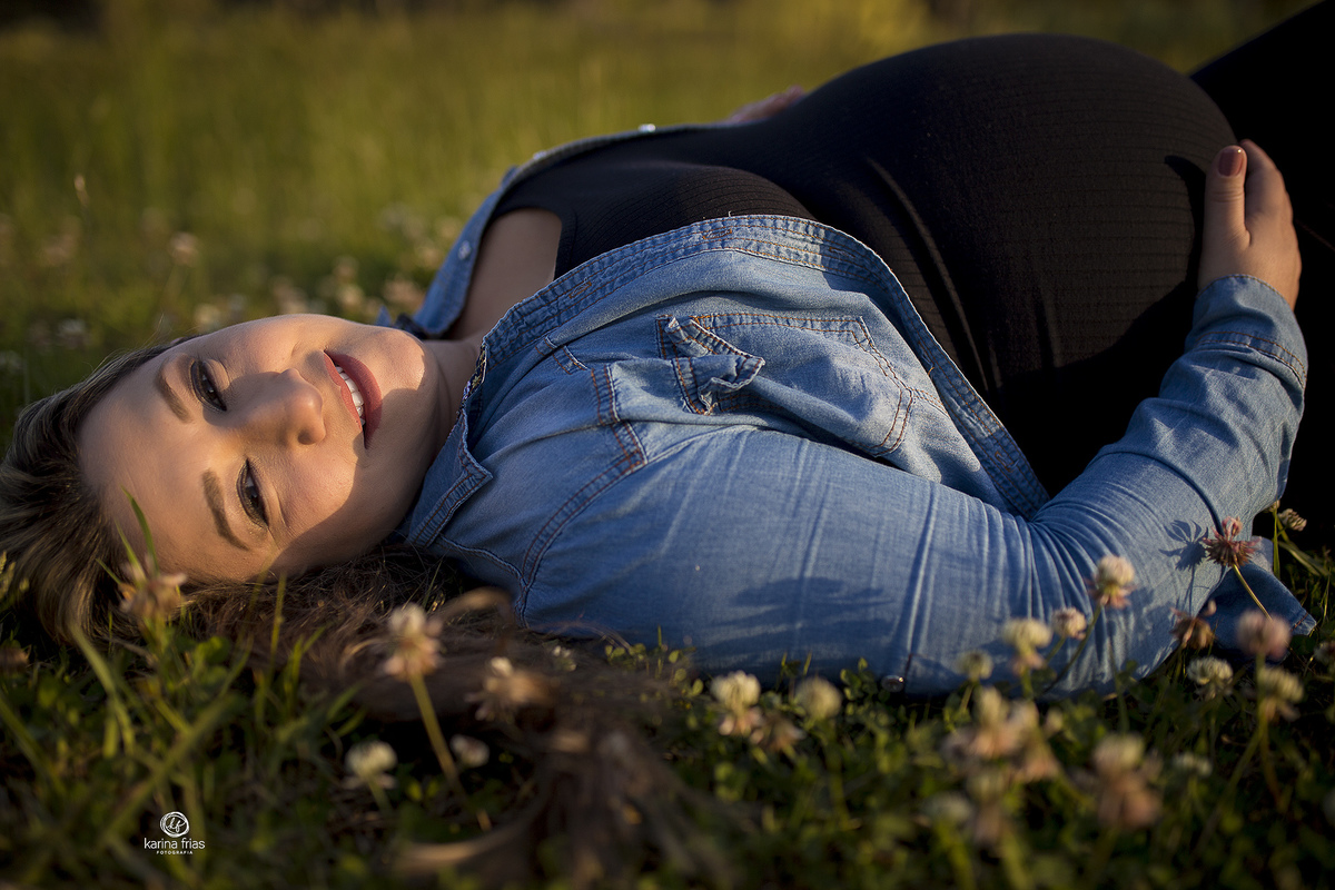 a gestante esta deitada na grama 