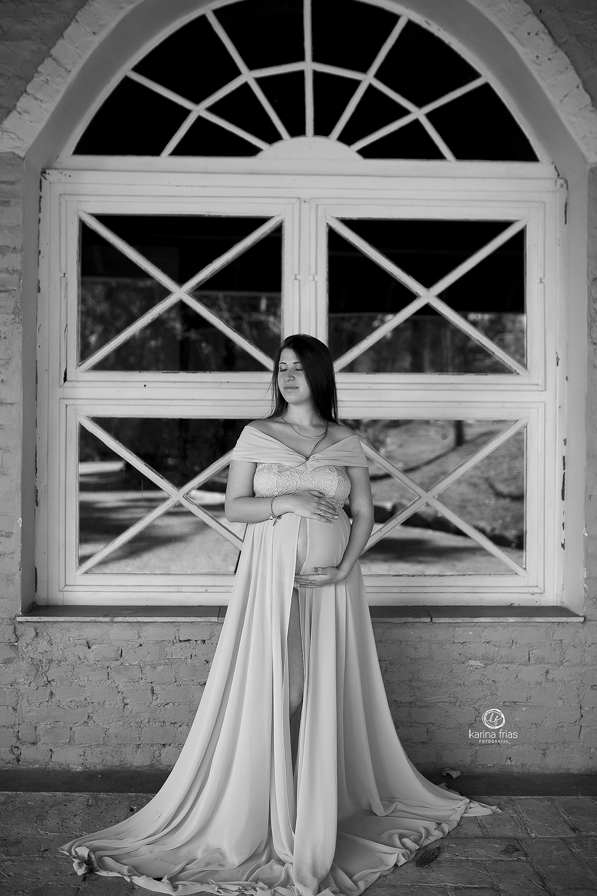 a modelo posa em meio a uma janela nas suas fotos de gestante