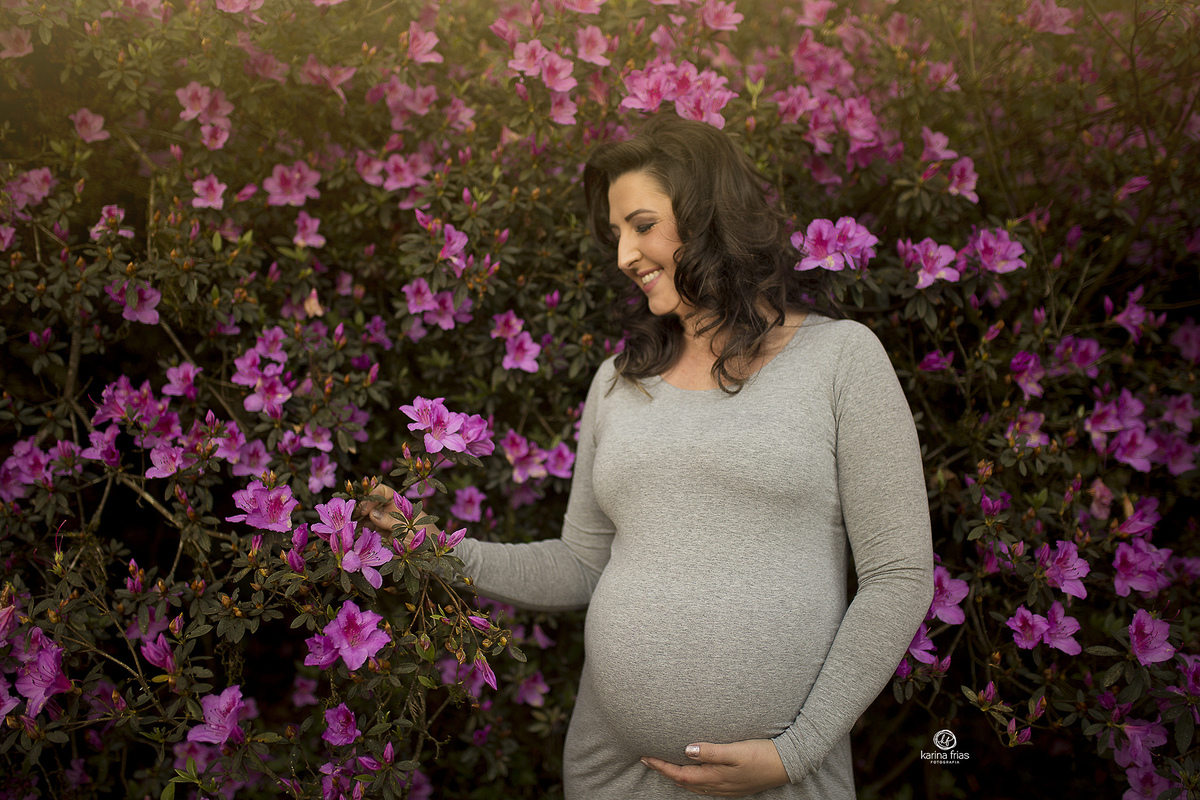 a mae olha as flores enquanto a fotografa de familia registra o momento