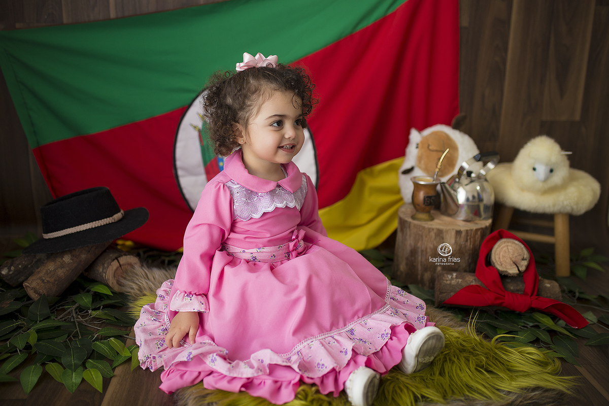 a menina esta sentada no cenario de gaucho para a sessão