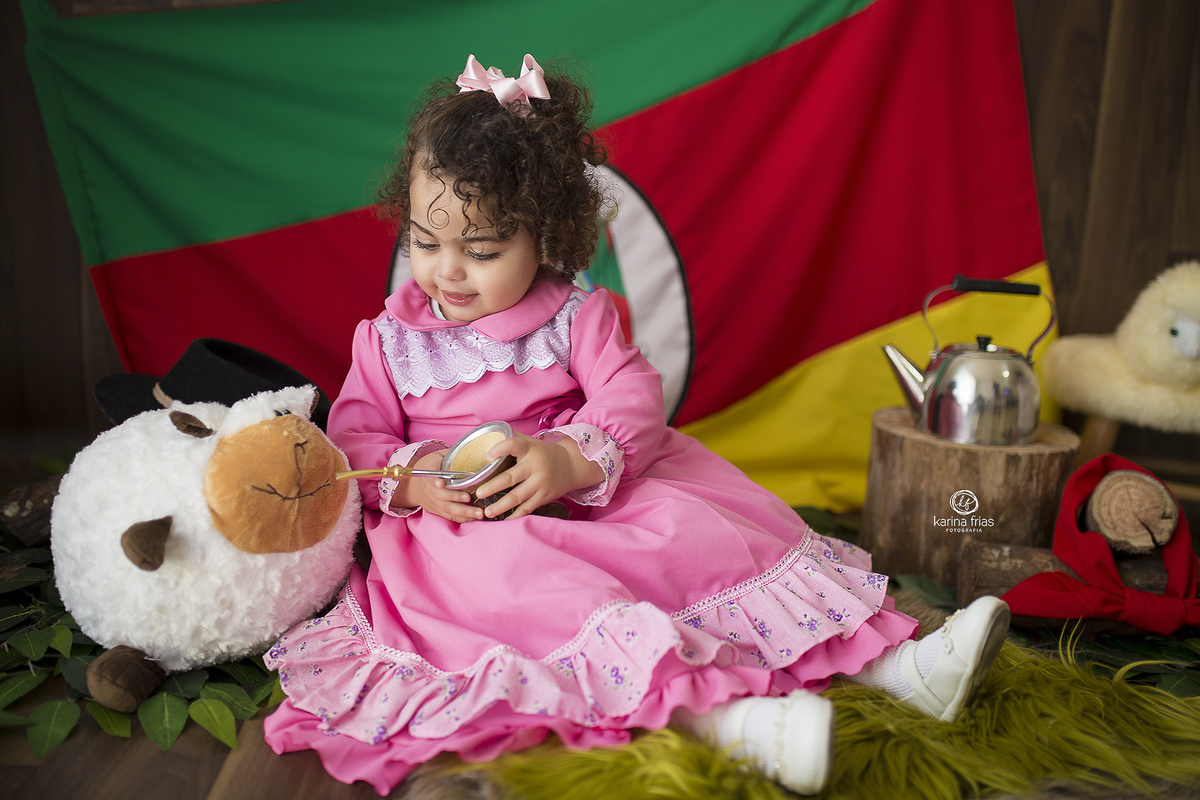 no ensaio de gaucho, a menina da chimarrao para a ovelha