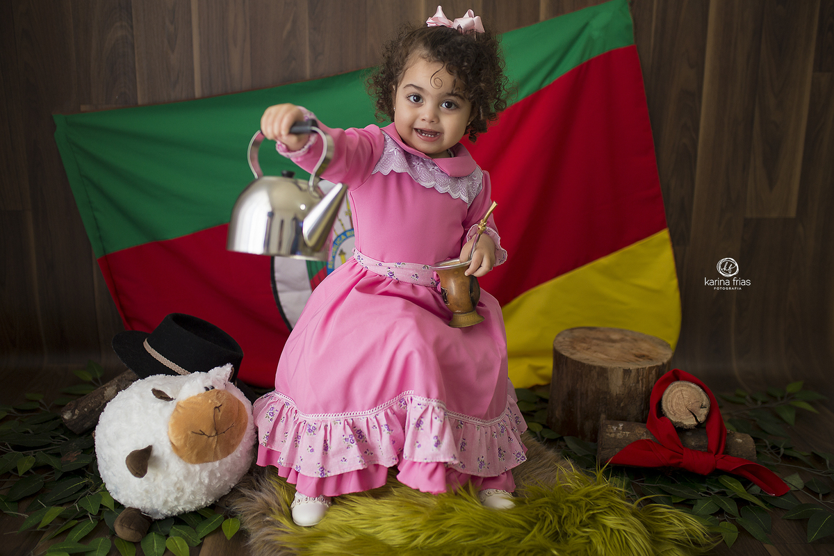 a menina sorri durante sessão de fotos infantil