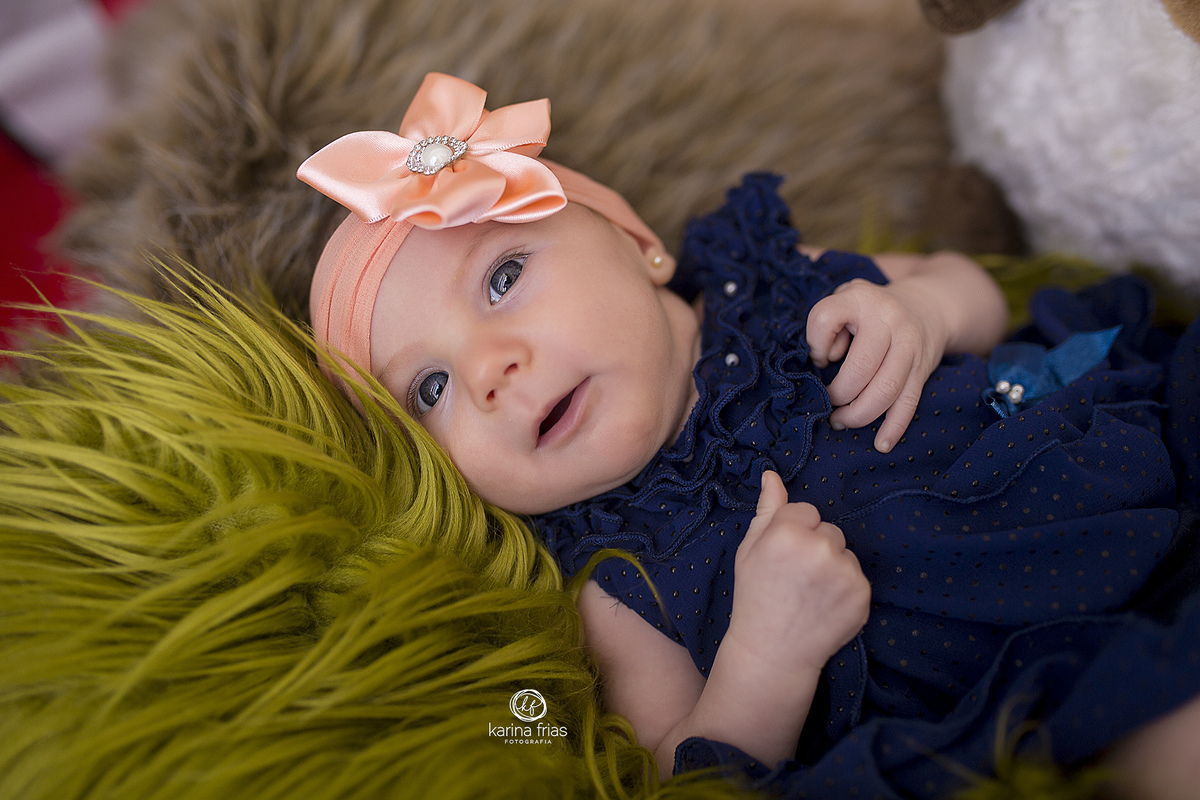 a bebe sorri durante a sessão de fotos infantis