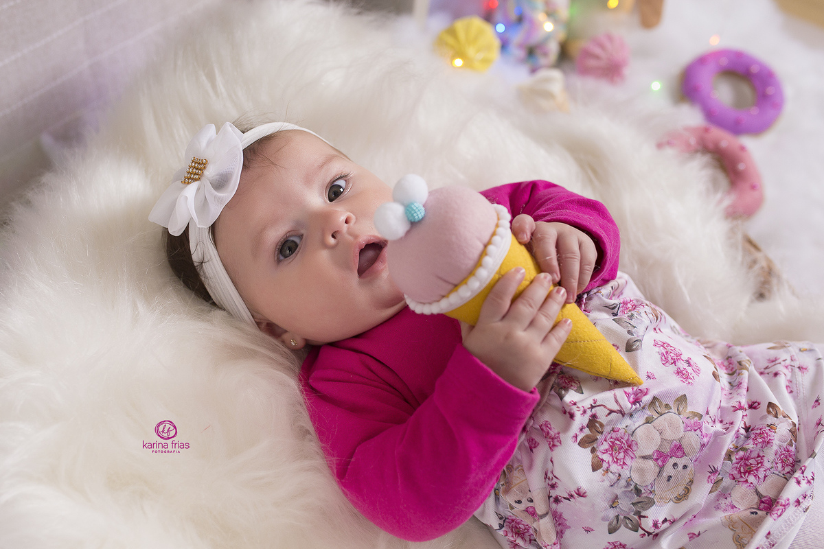 no ensaio infantil, a bebe segura o sorvete de brinquedo