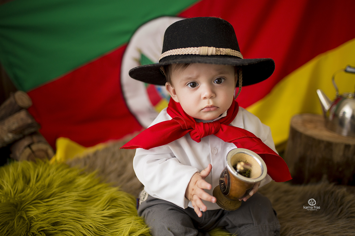o menino esta no cenario de gaucho para as fotos de acompanhamento mensal