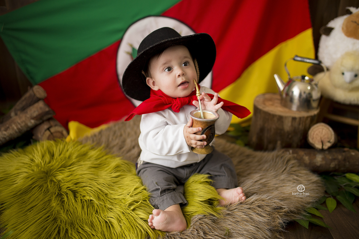o menino segura a cuia do chimarrao na sessão de fotos