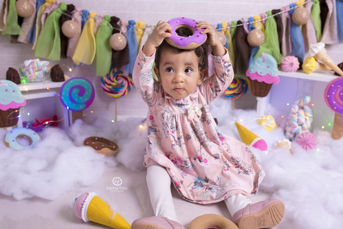 a menina poe o doce na cabeça durante sessão de fotos