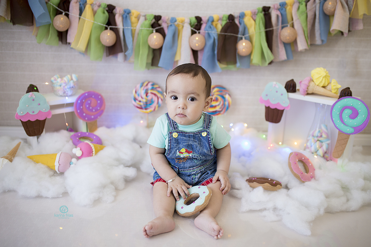 o bebe esta sentado no cenario de dia das crianças