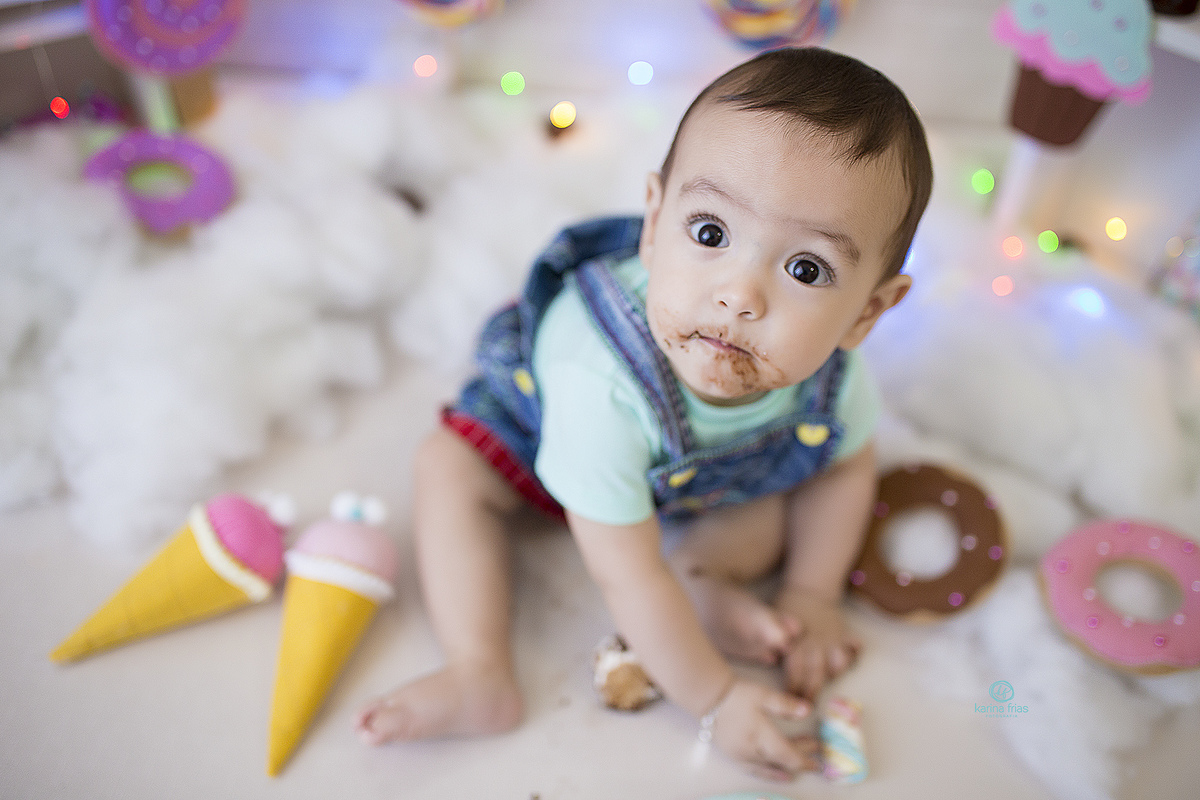 no ensaio infantil o bebe levanta a cabeça para olhar para a camera