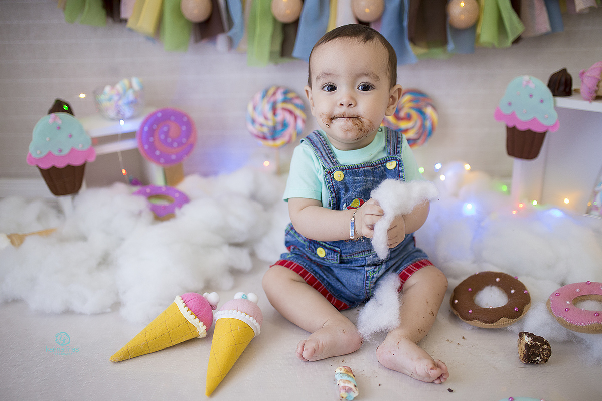 o menino brinca com as coisas do cenario durante sessão de fotos