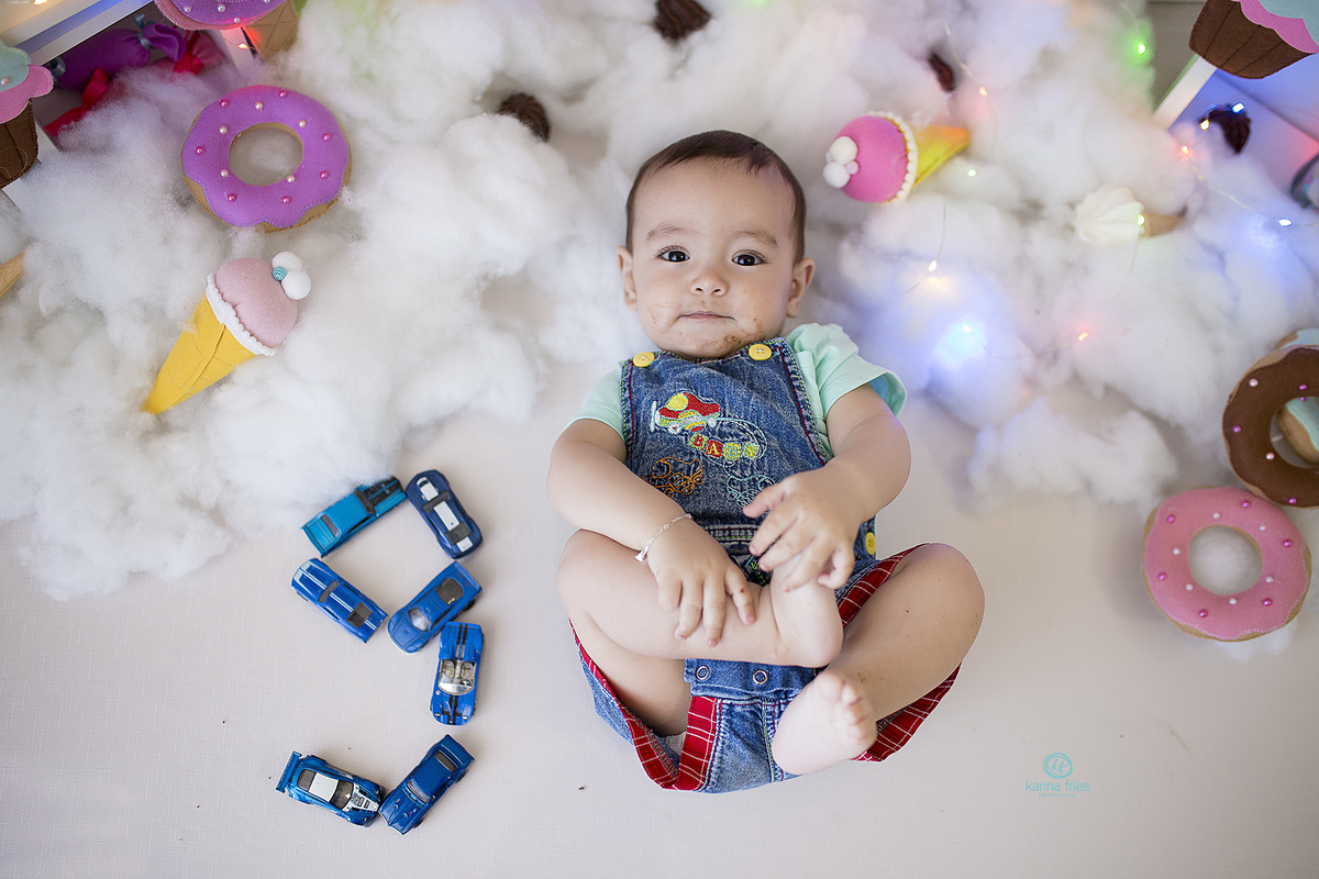 o menino esta deitado no chao para as fotos do seu acompanhamento mensal