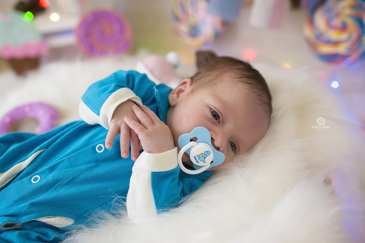 o bebe esta deitado para as fotos do seu primeiro mes