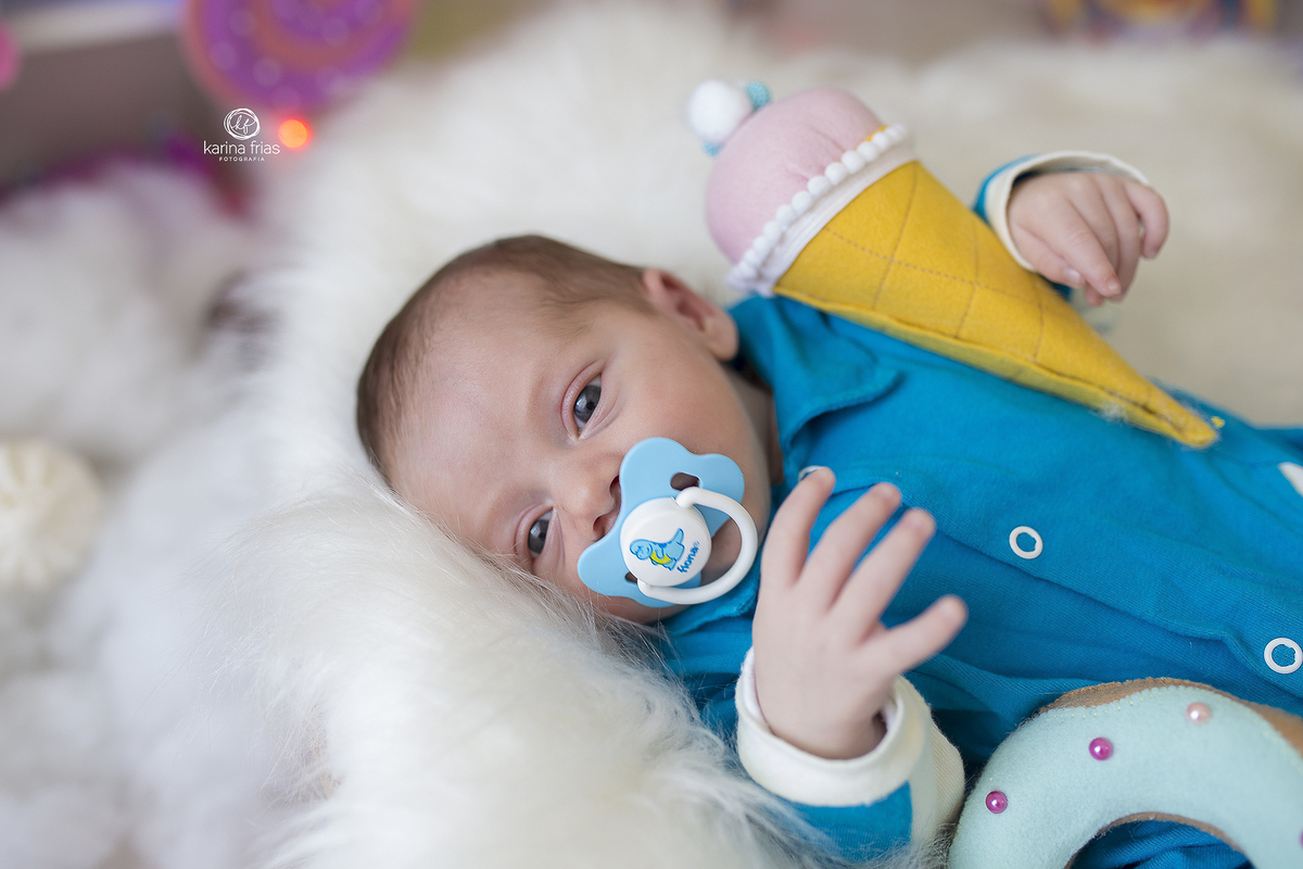 o bebe esta abraçado no sorvete que compoe o cenario de dia das crianças