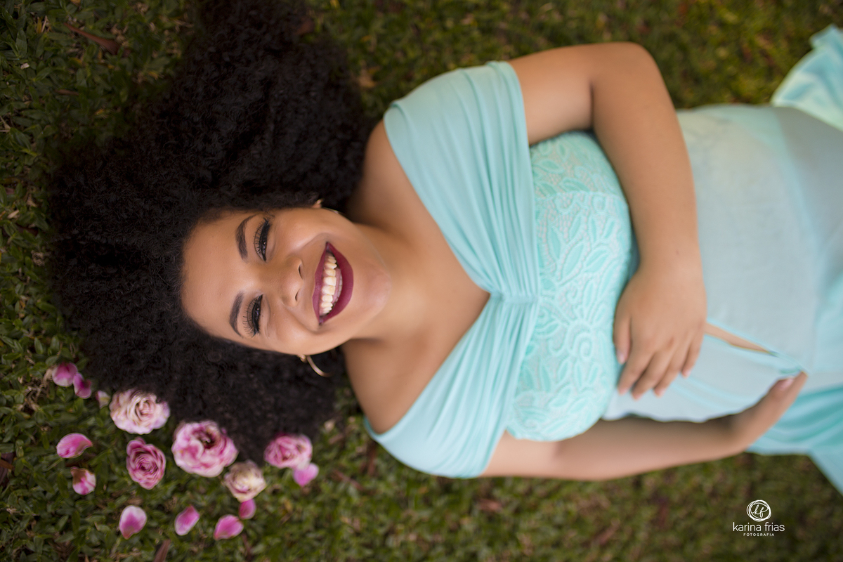 a mamae esta deitada no chao com flores no cabelo para suas fotos de gestante