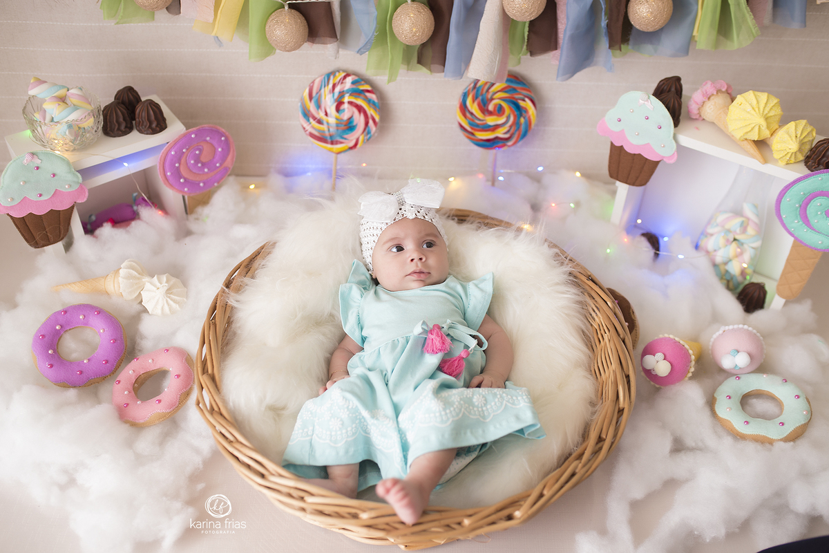 a menina esta deitada no cesto para as fotos do seu segundo mes