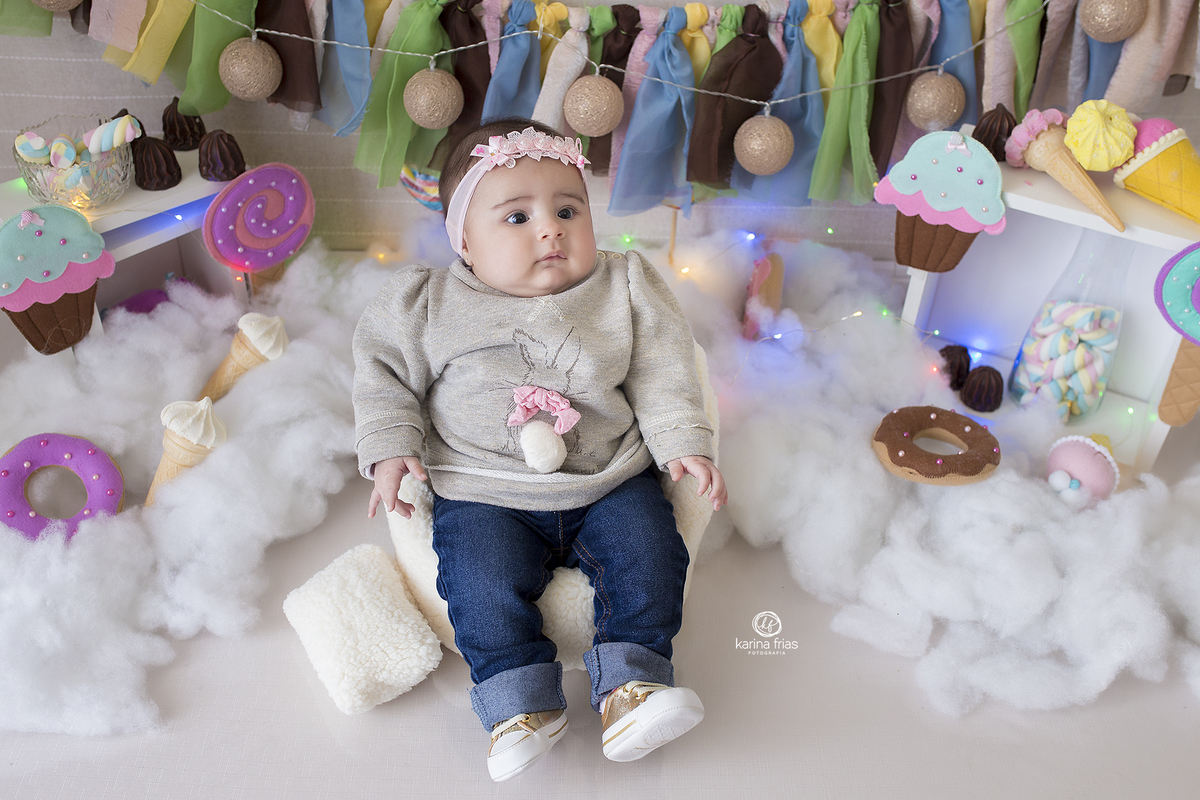 a menina esta sentada no cenario de dia das crianças