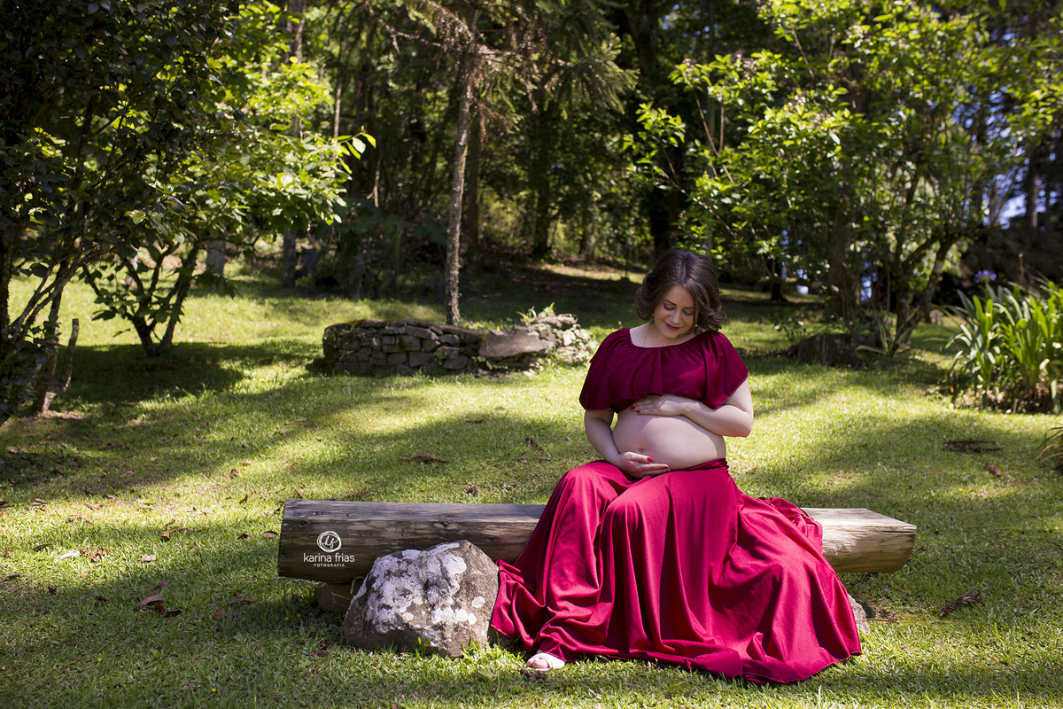 a gestante olha para a barriga durante ensaio externo