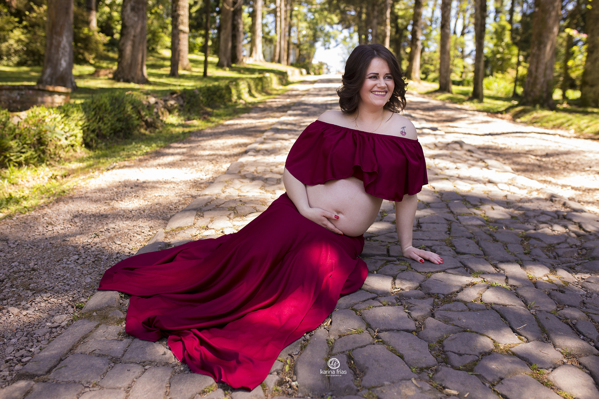 a gestante esta sentada para as fotos do seu book de gestante