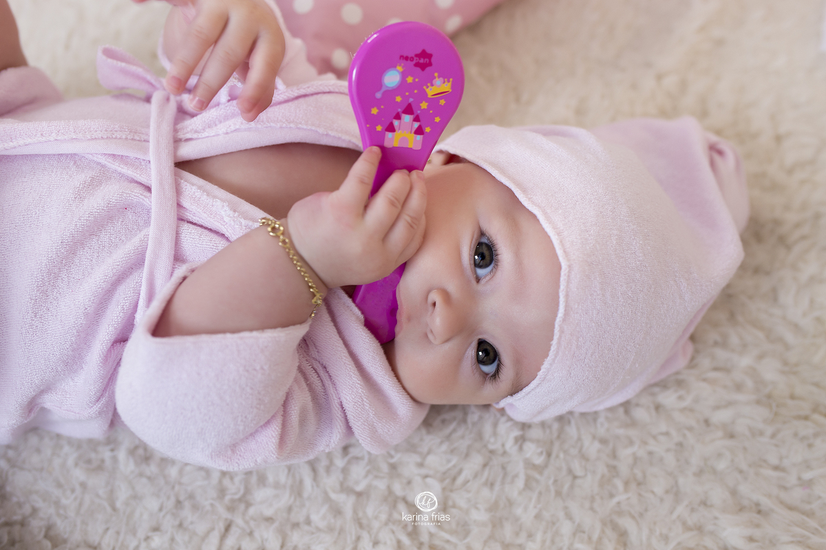 a bebe esta com a escova na boca para as fotos mensais
