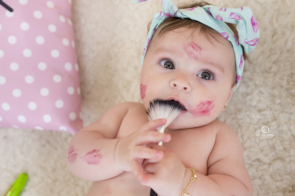 a bebe coloca o pincel na boca