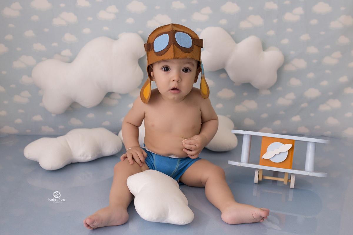 o bebe esta vestido de aviador para suas fotos mensais