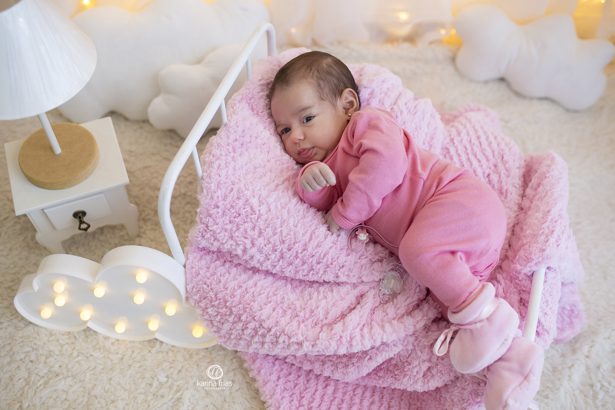 no ensaio infantil, a bebe esta deitada na cama