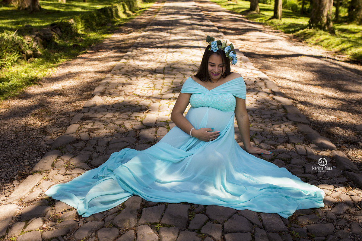 a gestante olha para a barriga durante ensaio externo