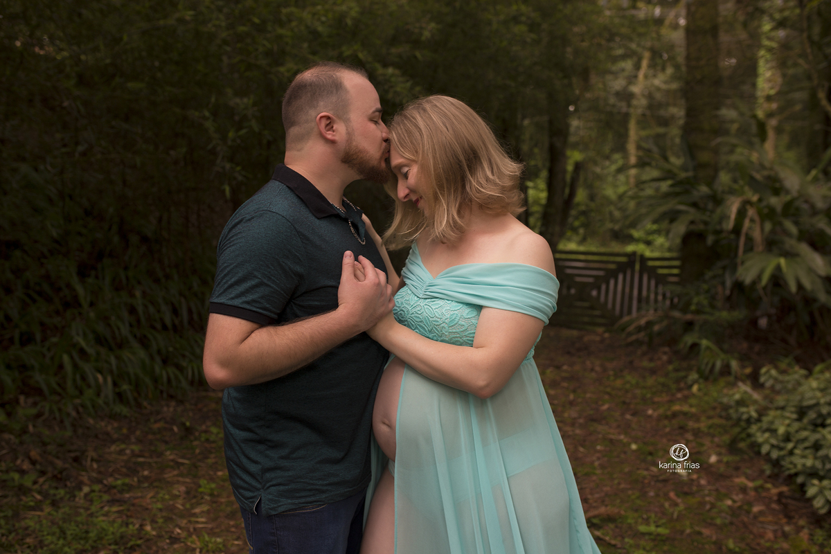 no ensaio de gestante externo o pai beija a testa da mae