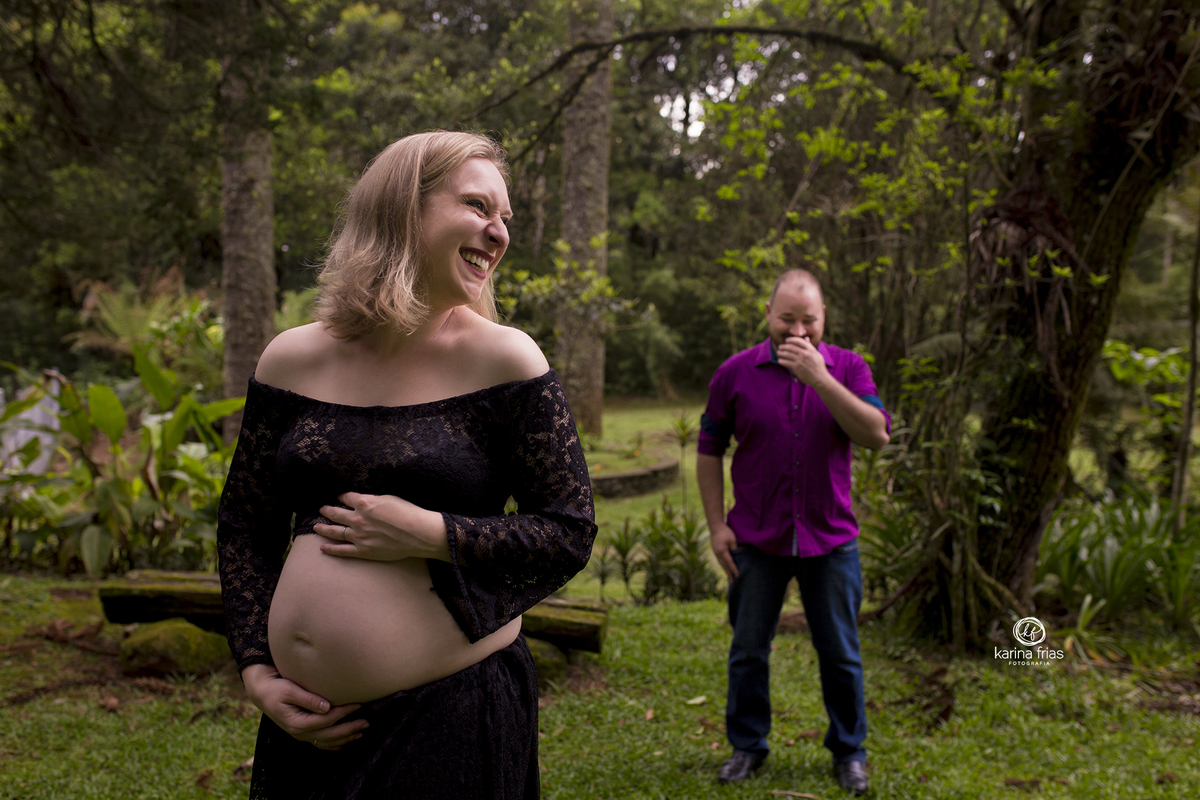 no ensaio externo de gestante os pais sorriem para a fotografa de gestante, karina frias