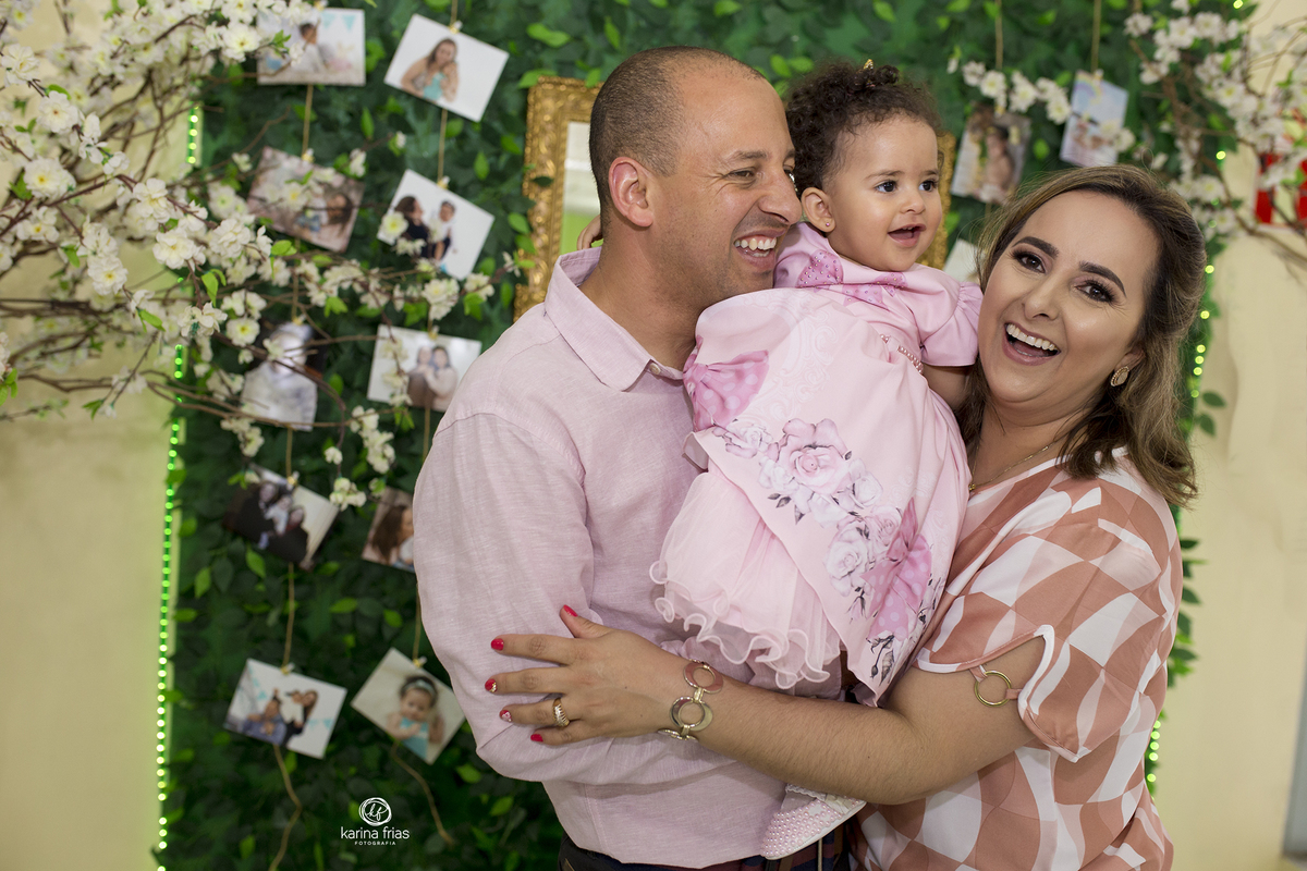 os pais abraçam a filha no aniversario infantil