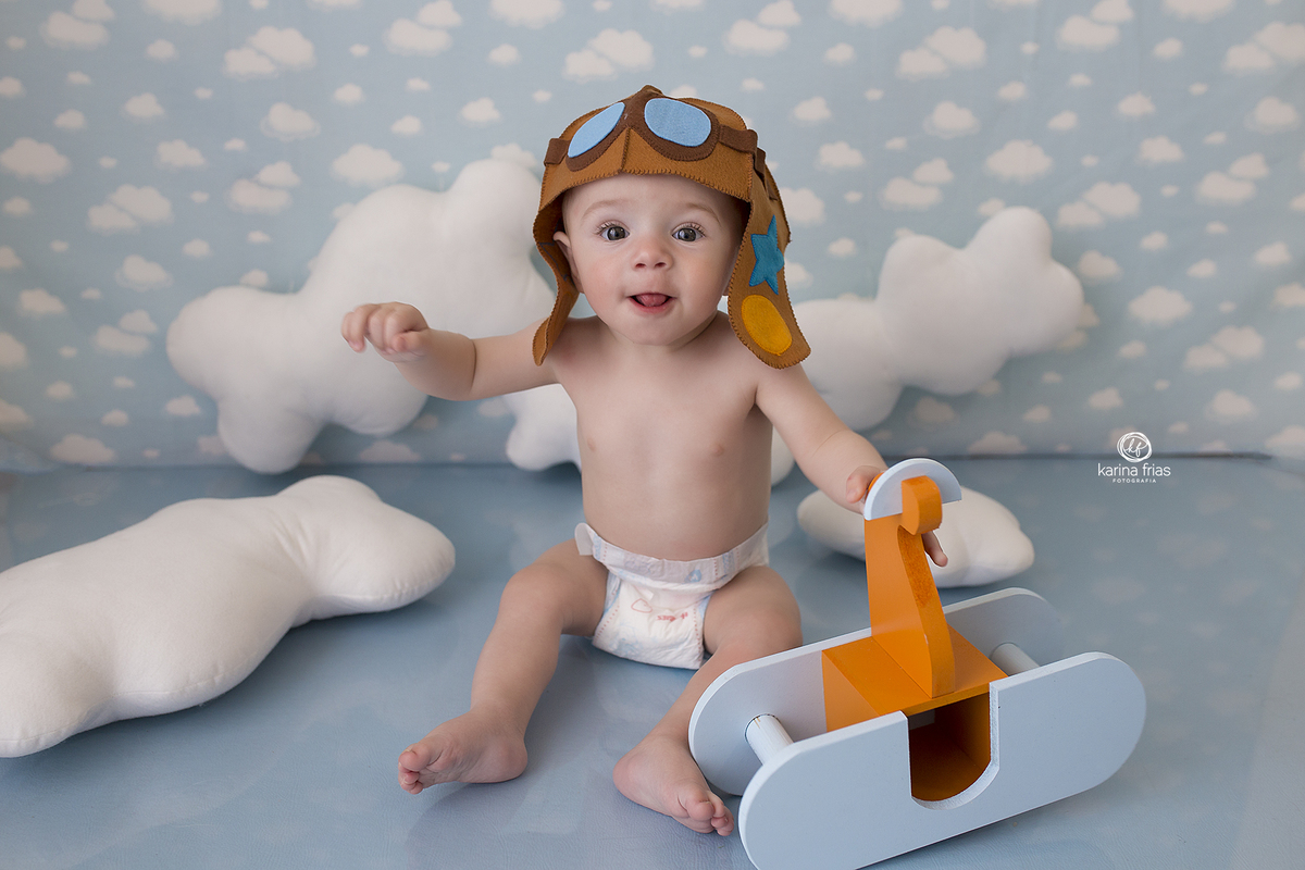 o menino esta no cenario de aviador para as fotos mensais