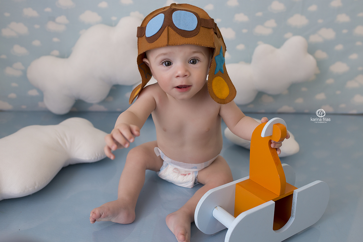 no acompanhamento mensal o bebe segura o aviao